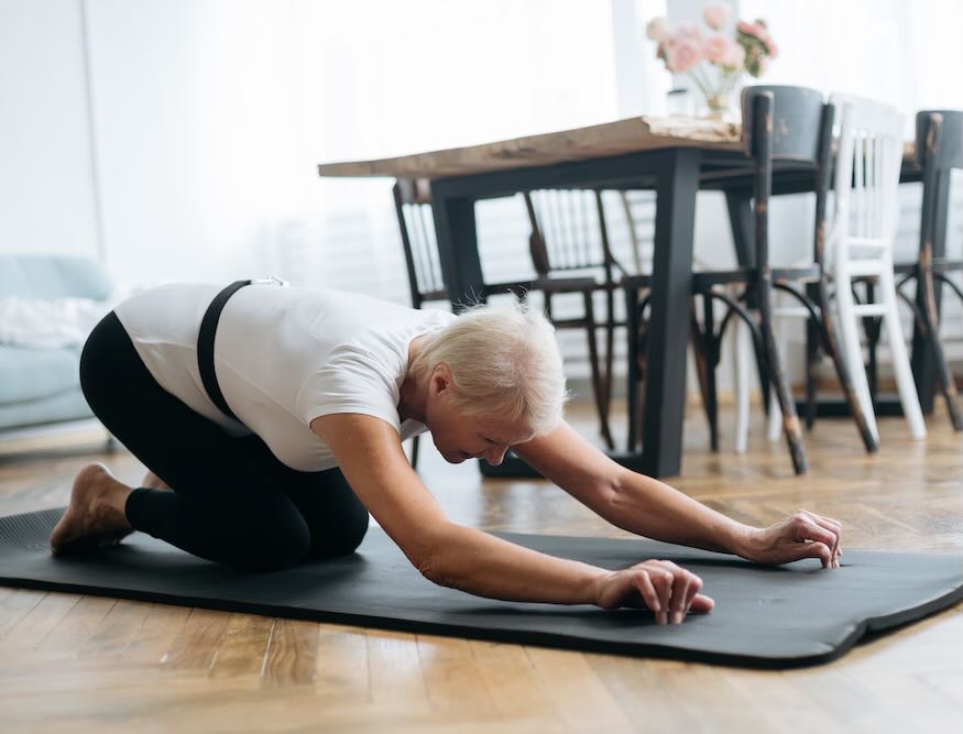 elderly woman doing morning exercises in the living room.